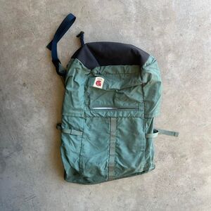 Green and black Fjällräven Kanken backpack with waterproof fabric, multiple pock
